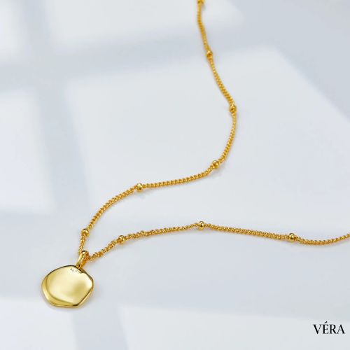 Dije dorado en forma de estrella brillante
