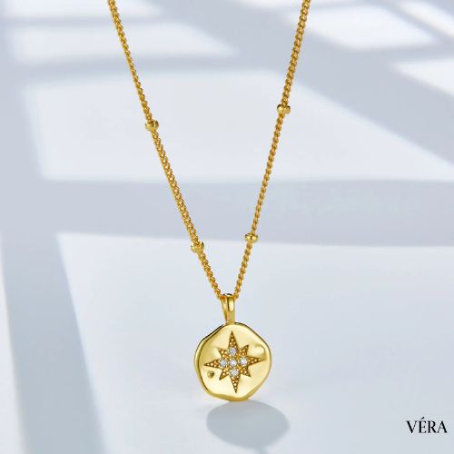 Collar de estrella dorada sobre bolsa de regalo